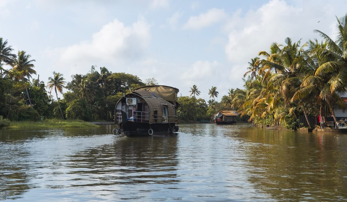Дом на воде на реке, окруженный пальмами, Керала, Индия