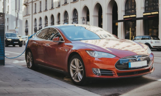 Красный автомобиль Tesla заряжается